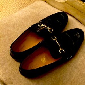 Gucci black patent leather loafer.  Classic horse bit slip on.